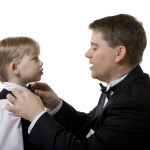 Man Fixing Bow Tie on a Boy's Suit